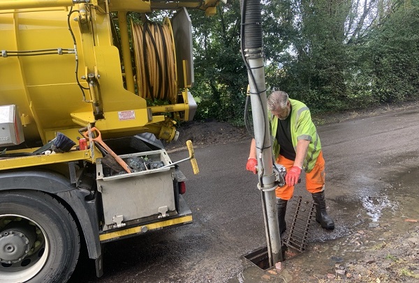 A council worker clearing a drain in Henfield Road between floods.