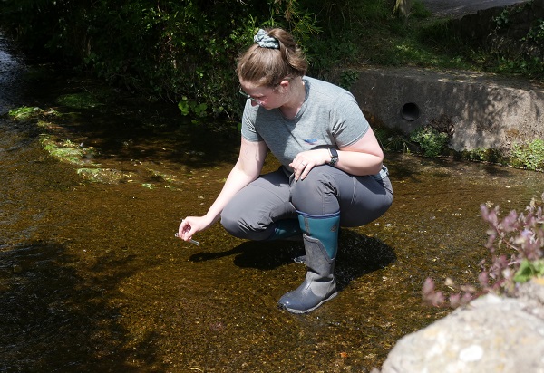 A volunteer takes a sample for the 2025 RiverBlitz